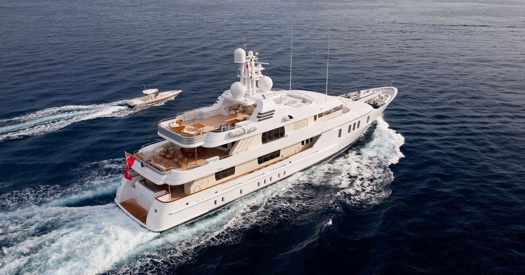 luxury yacht HANIKON cruises on a charter vacation alongside tender