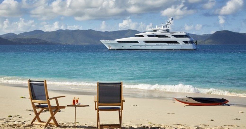 Victoria del mar in distance with director-style chairs and table on sandy beach in foreground