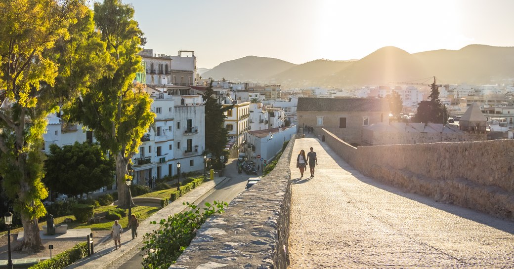 couple holding hands walking through ibiza old town