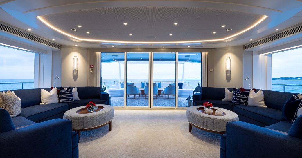 Main salon onboard luxury yacht rental SANTOSHA with blue sofas