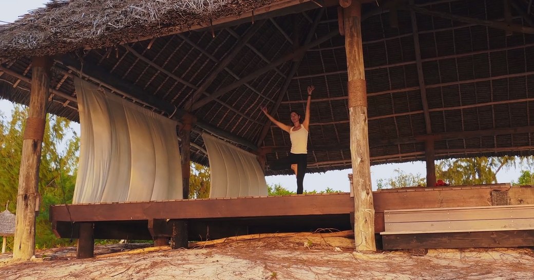 woman practises yoga on stage on thanda island