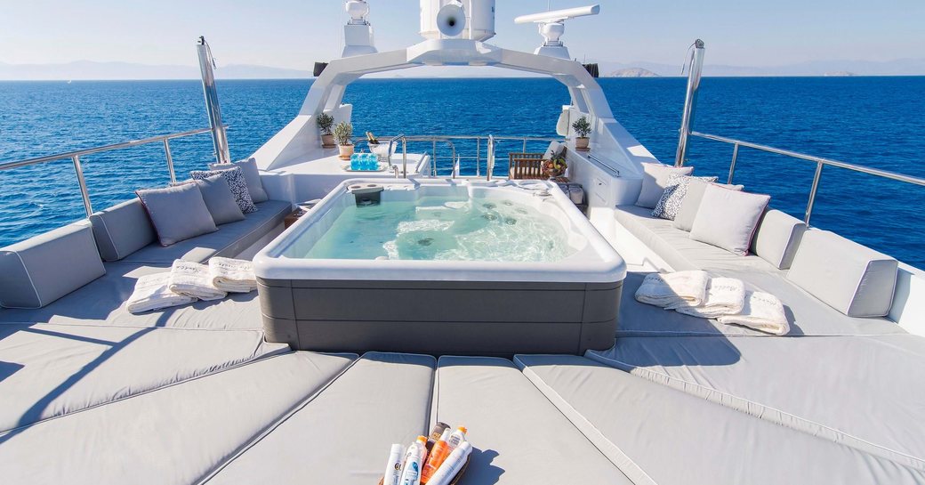 Overview of the deck Jacuzzi and surrounding sunpads onboard charter yacht BELLA STELLA