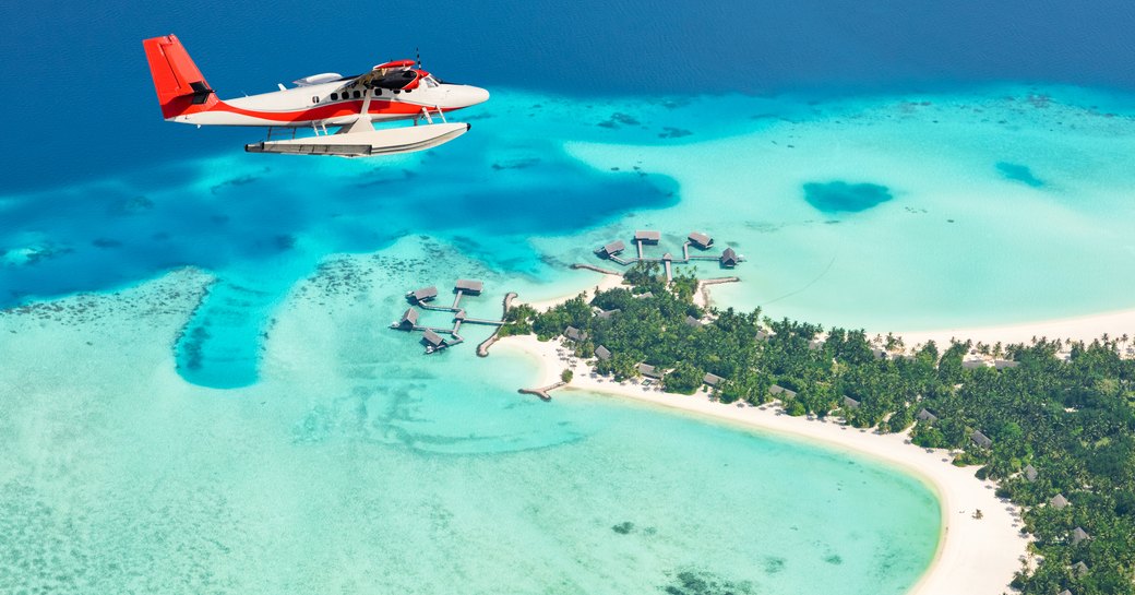 Seaplane exploring aerial views of Maldives, surrounded by island below and aquamarine waters