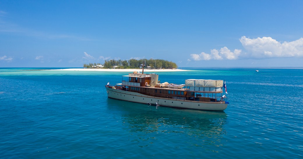 thanda private island and marine reserve with luxury yacht over the rainbow anchored nearby