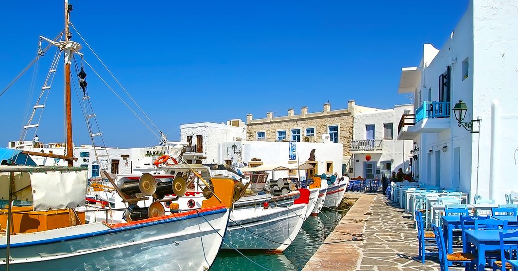 Fishing village in Greece with small boast and white-washed buildings