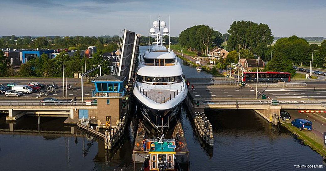 luxury yacht podium goes through gap in waterway canal