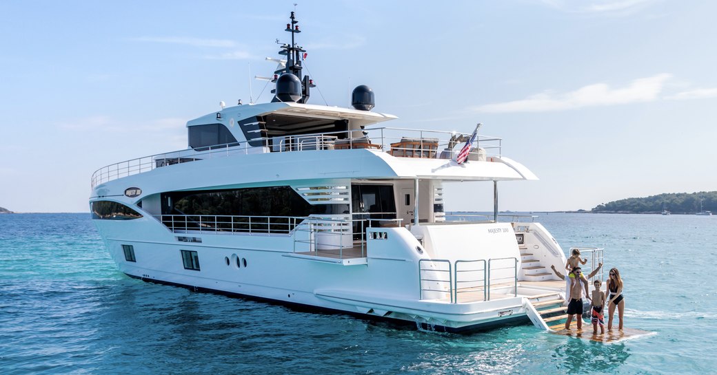 charter guests on submersible swim platform of motor yacht ONEWORLD