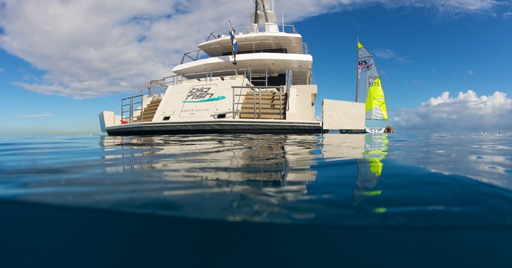 transom and stern of superyacht ‘Big Fish’ anchored next to wind surf