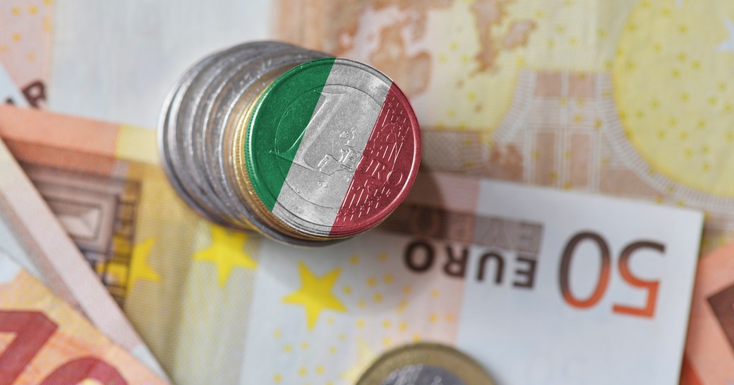 Coins on euro note with Italian flag printed