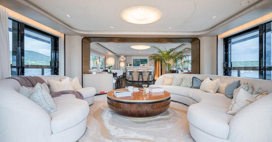 Interior lounge area onboard charter yacht M with plush cream seating