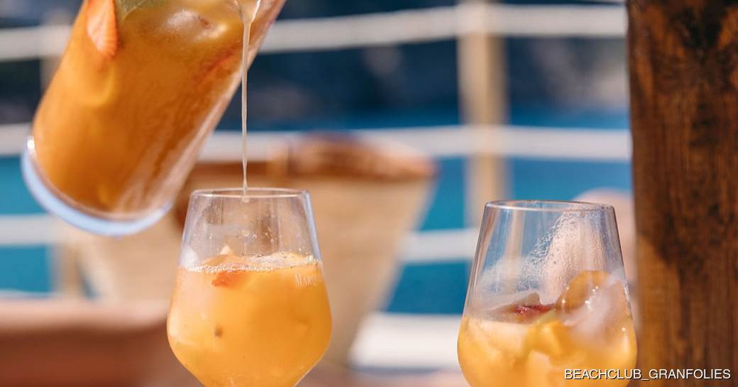 Cocktails being poured into two glasses