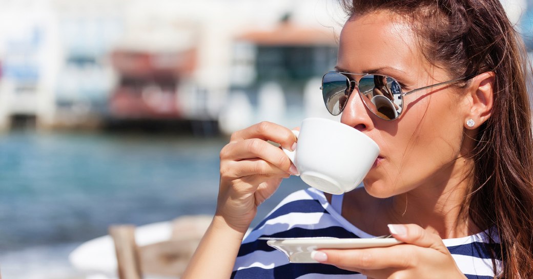 Woman drinking coffee at cafe in Mykonos 