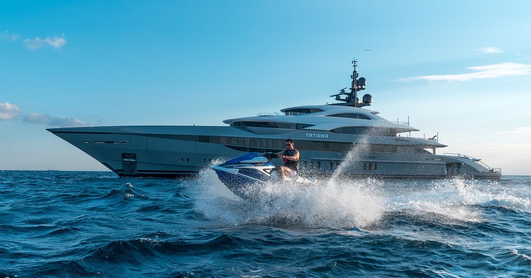 superyacht tatiana and charter guest on jet ski