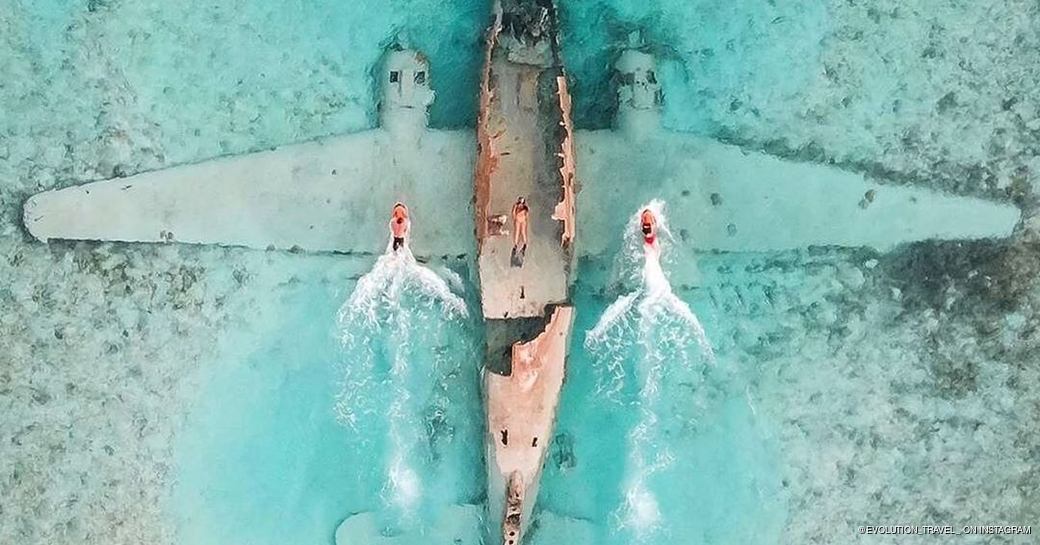 Aerial shot of two boats skimming over the Pablo Escobar plane wreckage 