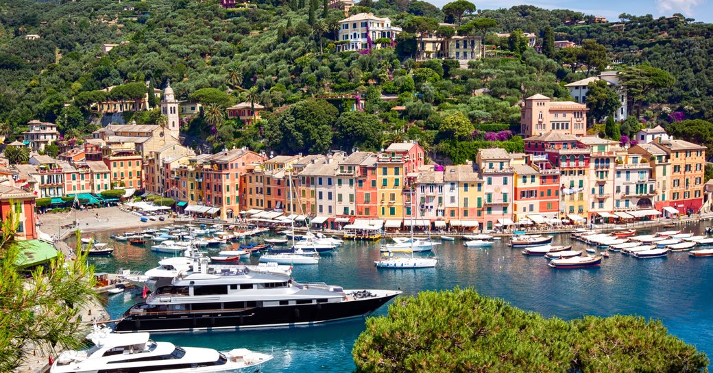 two superyachts and smaller boats lined up in Portofino Harbour