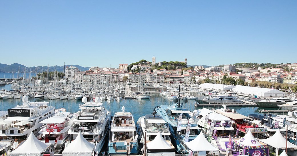 Marina at Cannes with all berths filled with motoryachts and sailing boats, Cannes settlement in background