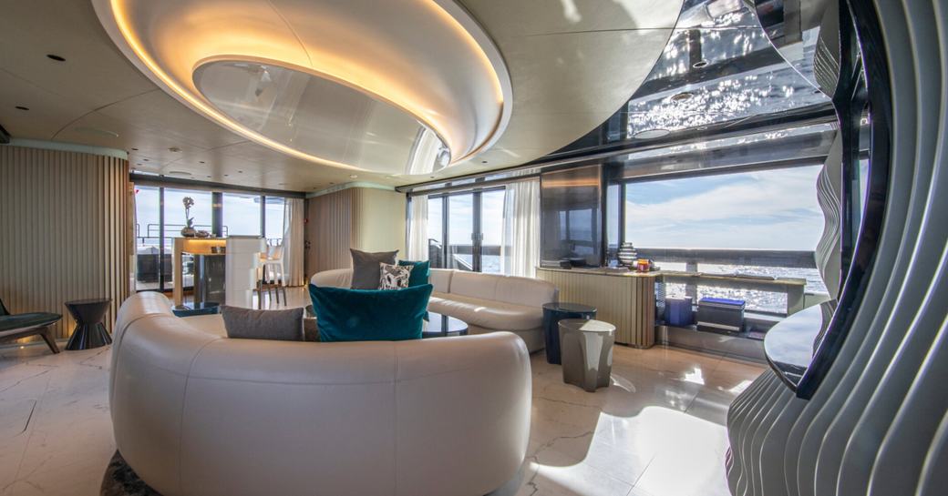 Overview of the main salon onboard charter yacht PANDION PEARL with plush seating and full height windows