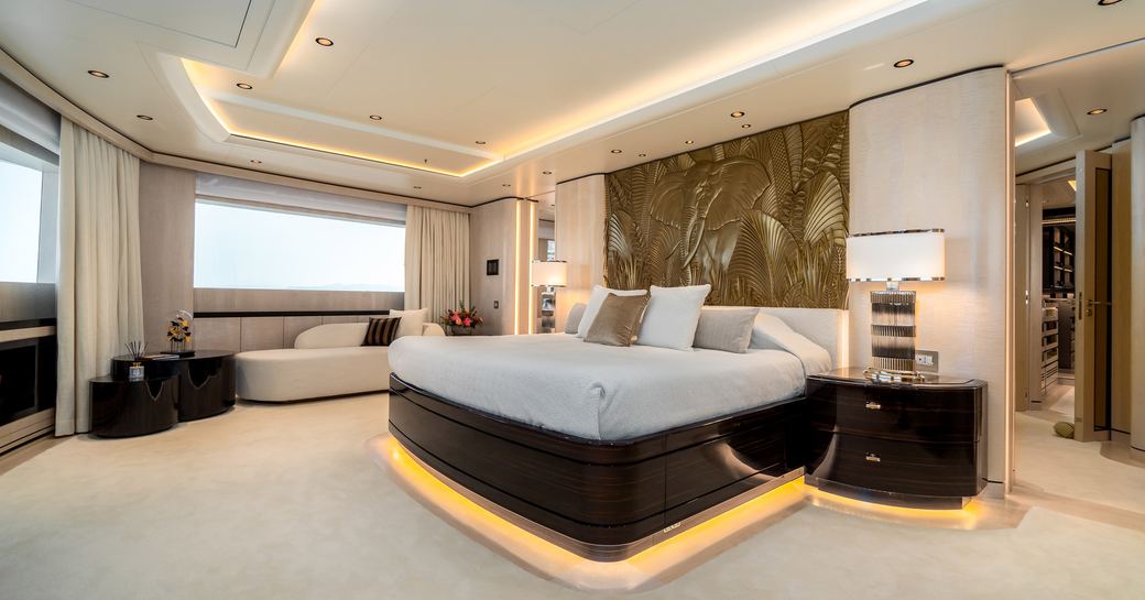 Large lightly colored suite on superyacht O'PARI, with king sized bed with artwork behind