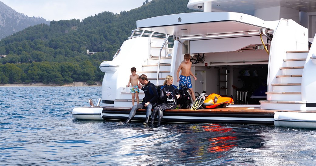 charter yacht spirit, with charter guests enjoying some scuba diving off the swim platform