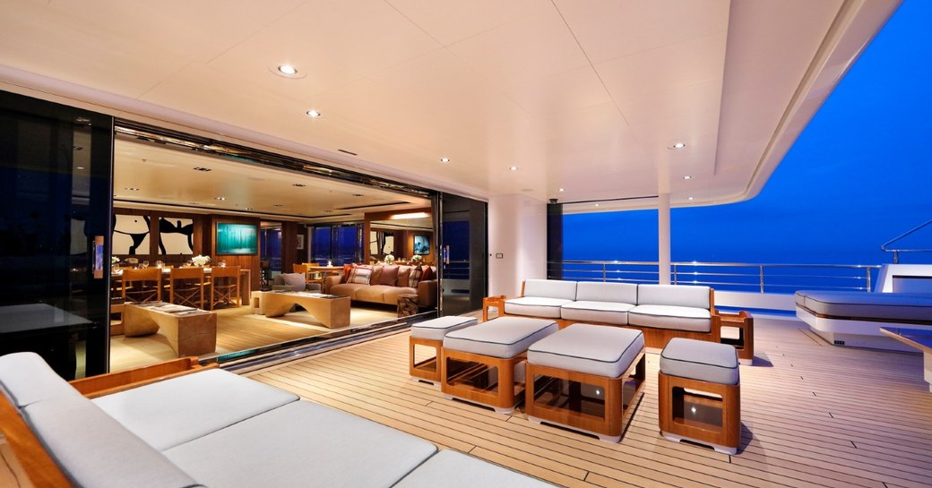 dining area al fresco on luxury yacht planet nine, with views of interior main salon in background