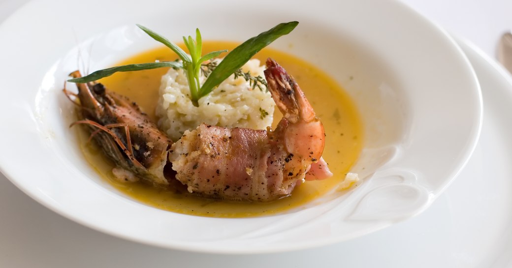 A fancy shrimp served on a white plate with a fancy decorating