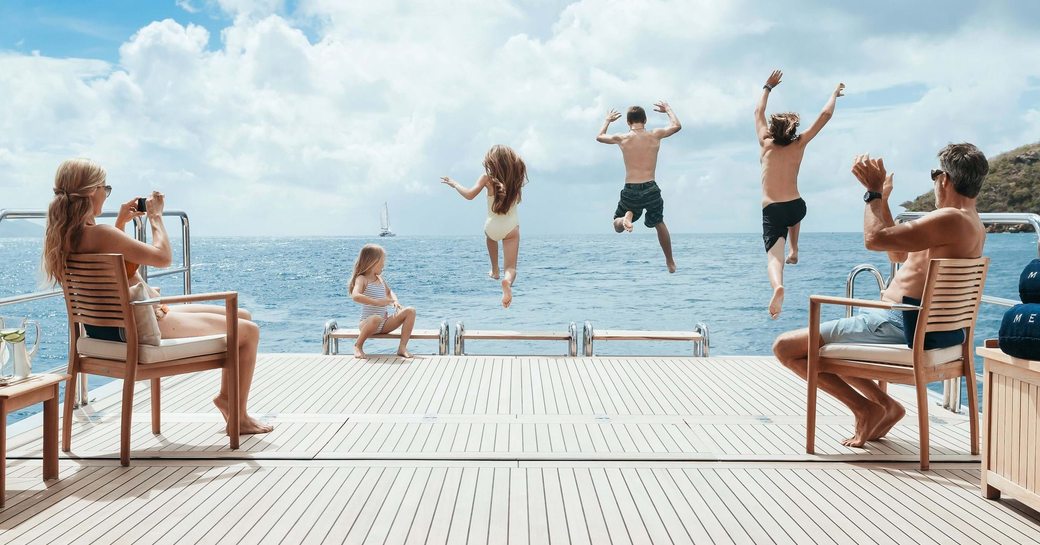 family jump off aft deck of superyacht 