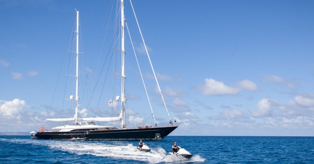 perini navi sailing yacht panthalassa at anchor with two charter guests using jet-skis around them