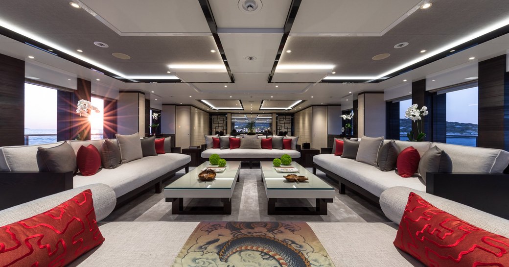 Main salon on luxury yacht SAMURAI, with a two coffee tables, grey sofas and light panels in the ceiling