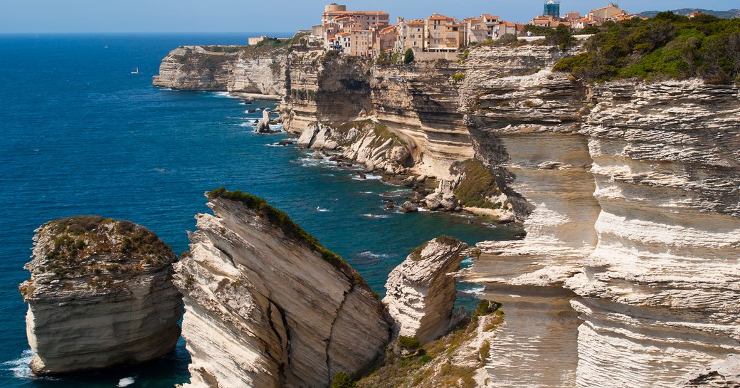 ancient village atop towering rocky cliffs overlooking the sea