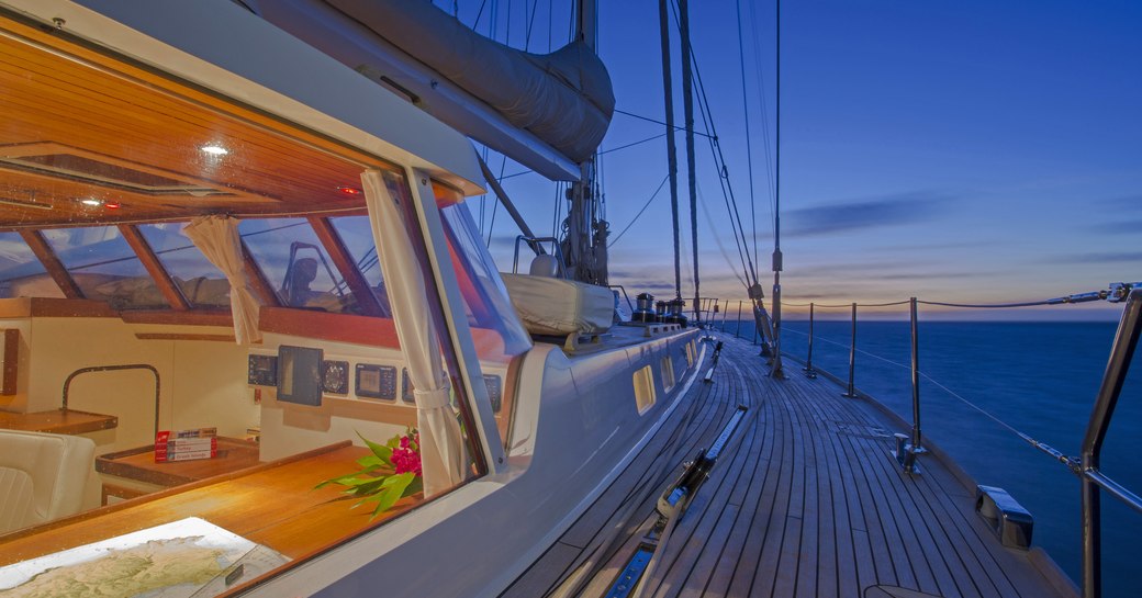 view of sunset from side deck of superyacht JUPITER with view into main salon