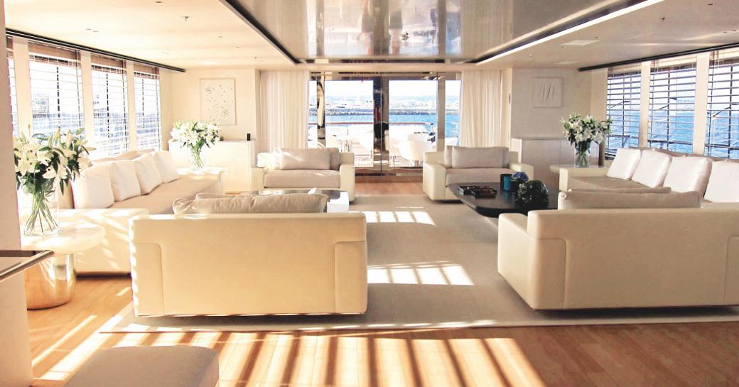 Overview of the main salon onboard charter yacht AIR, with plush cream seating and large windows