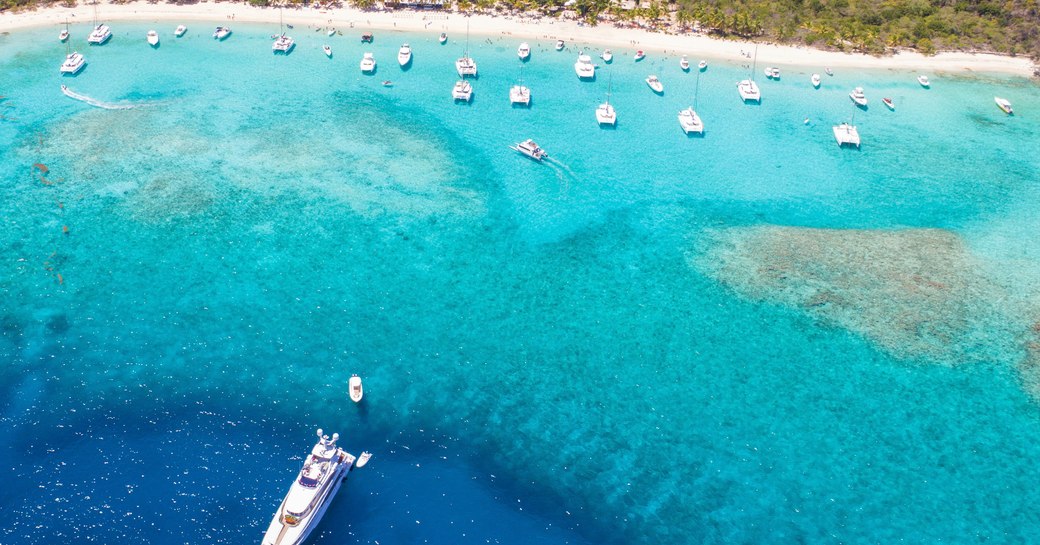 a superyacht cruising the multi hued tropical blue water of the virgin islands