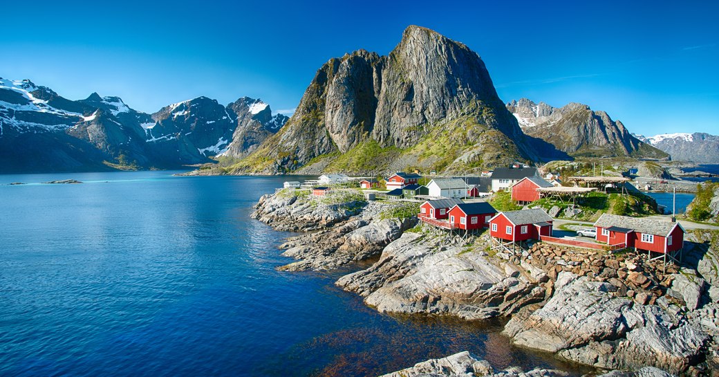Overview of coastline in Lofoten with red buildings at rocky edge