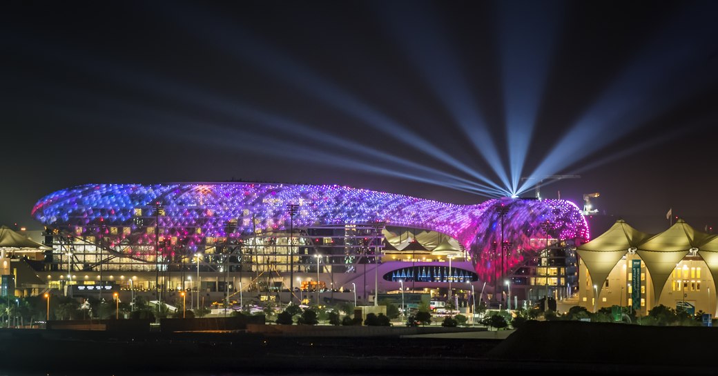 Abu Dhabi Viceroy hotel lit up at night, bright lights shine into darkness.