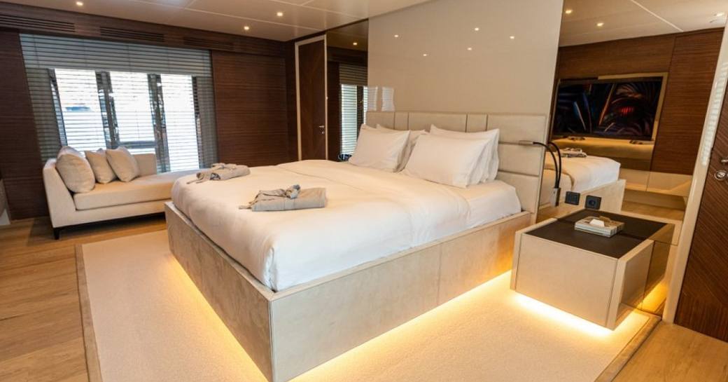 Master cabin with central berth and chaise longue in background onboard charter yacht ZEEMAR