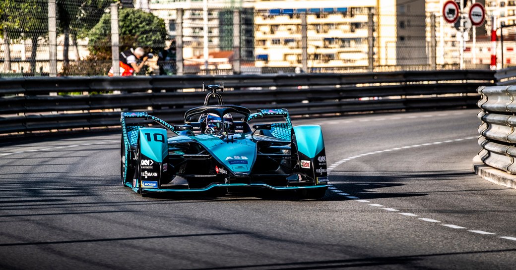 Teal Monaco E-Prix racer rounding a bend mid race.