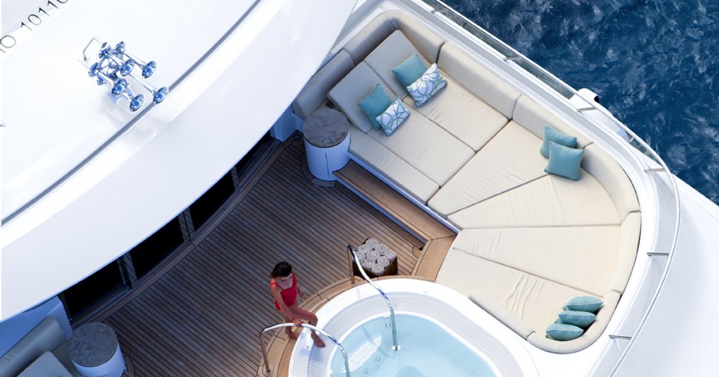 An aerial image which shows a model entering the Jacuzzi on the sundeck of a superyacht