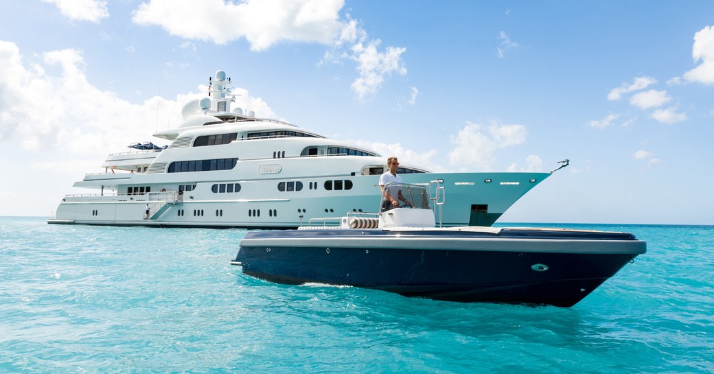 A deck crew member drives a tender from the yacht