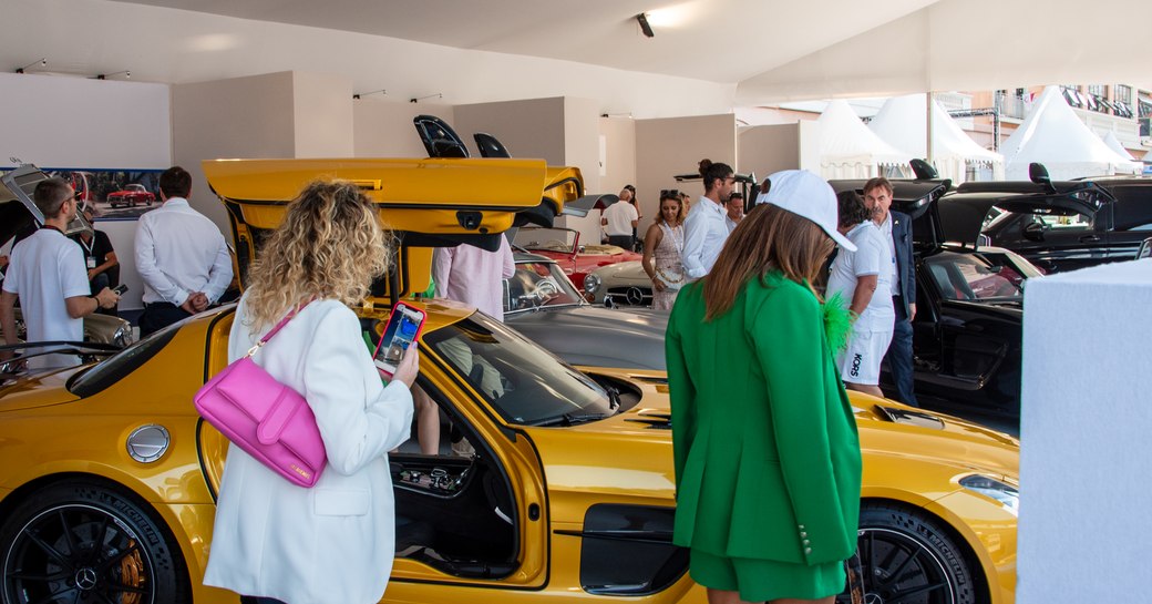 Female visitors at the Monaco Yacht Show viewing exotic cars