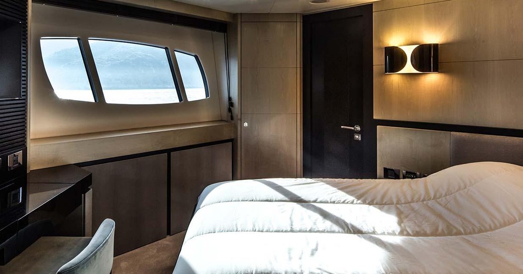 Double bed in cabin with light streaming through window on motor yacht Oksanchik