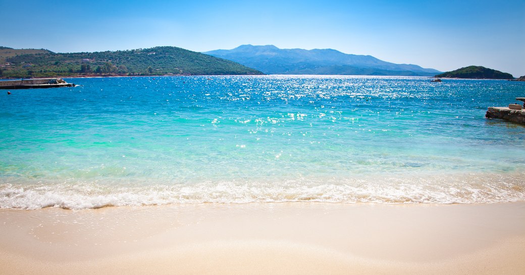 View from a beach out to sea, with mountains ahead