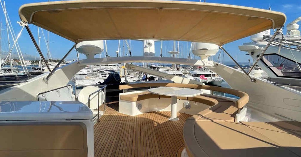 Flybridge onboard charter yacht ORLANDO L, abundant seating to starboard with views of a marina