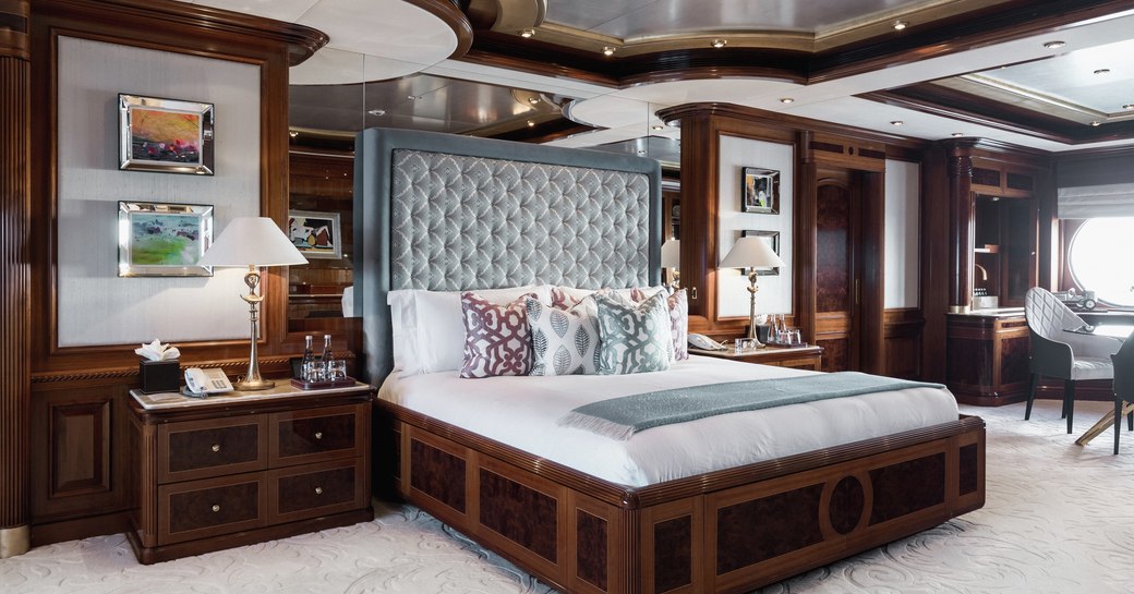 owner's cabin on charter yacht titania, with bed in centre and cherrywood surrounding 