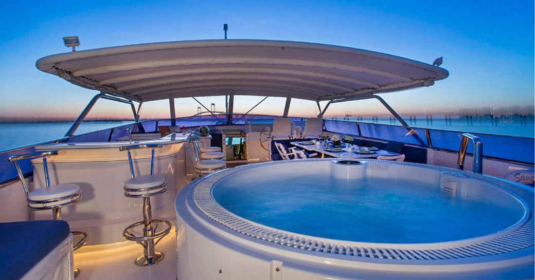 Jacuzzi, bar and al fresco dining area on the sundeck of motor yacht SAVANNAH as the sun sets