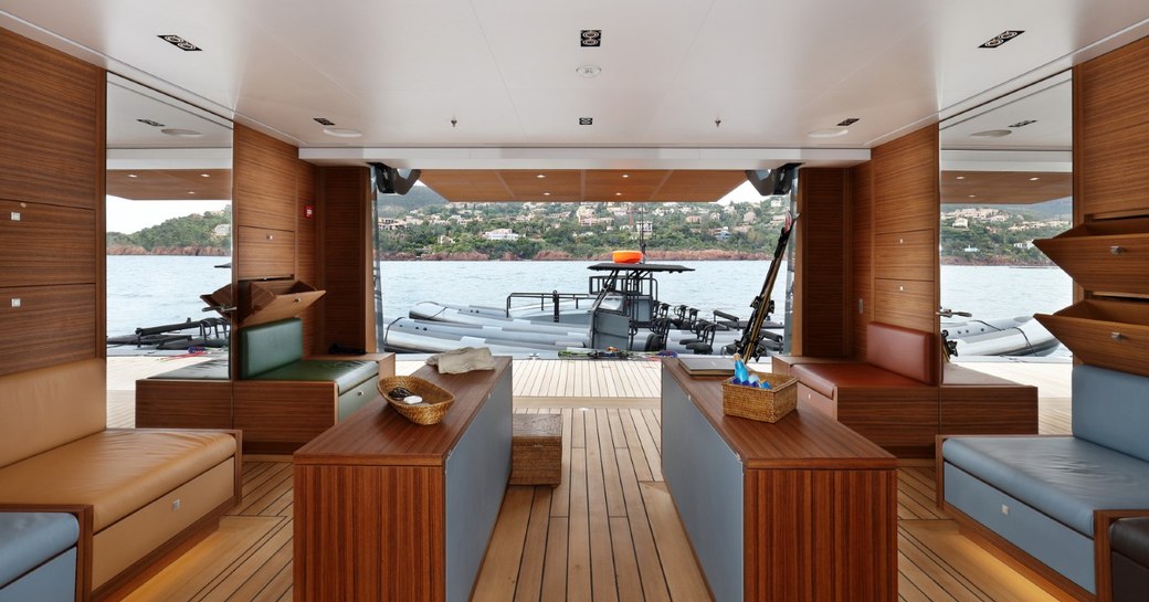 teak-clad beach club looking out onto tender on water aboard superyacht Planet Nine 