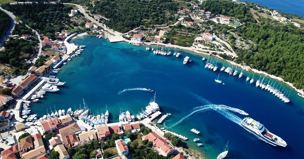 luxury harbour in greece with aerial view of yachts leaving port