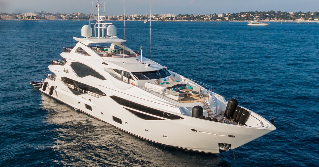 Overview of charter yacht SONISHI at anchor with land in distance