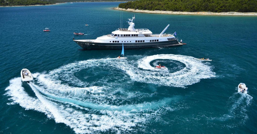 superyacht surrounded by blue sea and water toys