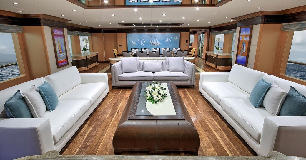 three sofas face a coffee table in the main salon aboard charter yacht MEIRA 