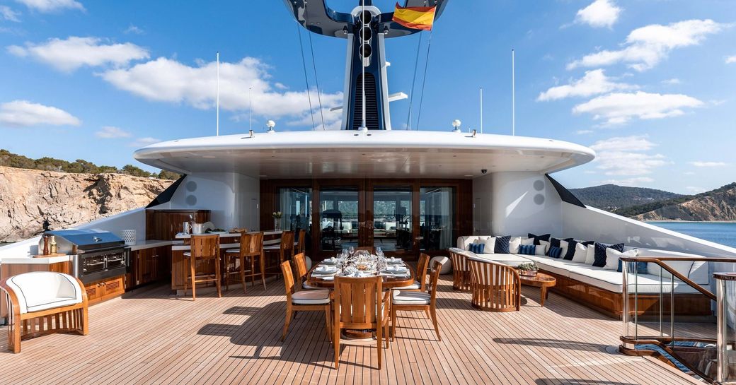 Sun deck area with alfresco lounge and dining table onboard superyacht charter SOPHIA